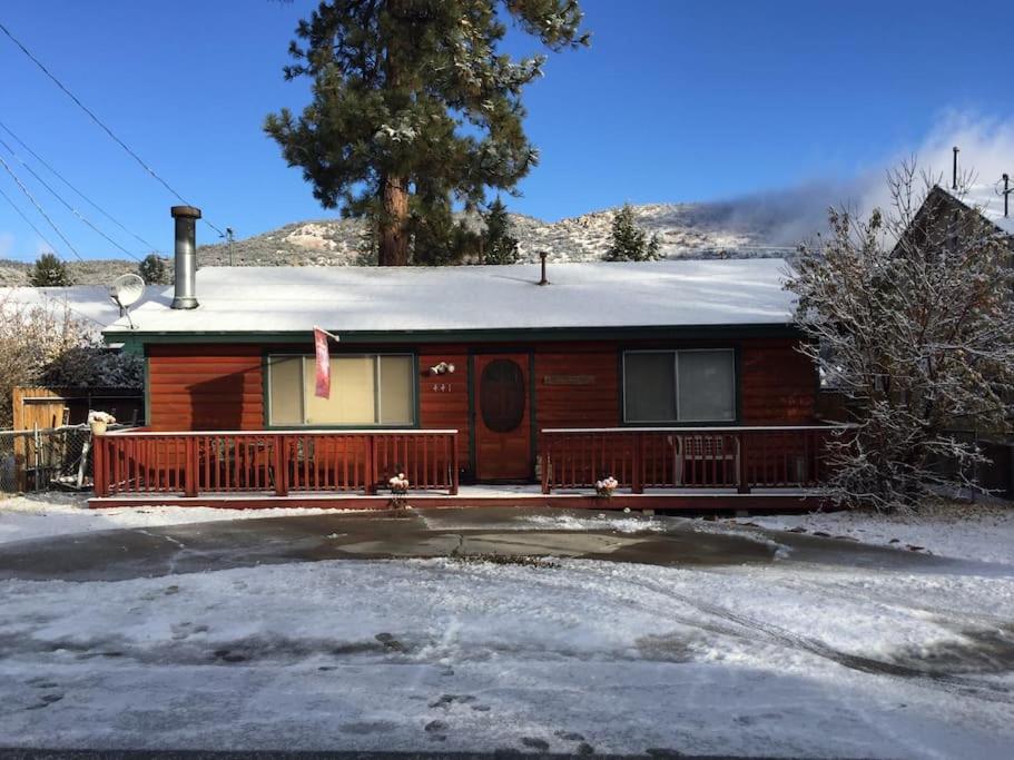 a wooden house with a snow covered roof at BEAR CABIN GETAWAY!!!(SPA) Pet Friendly Backyard in Big Bear City