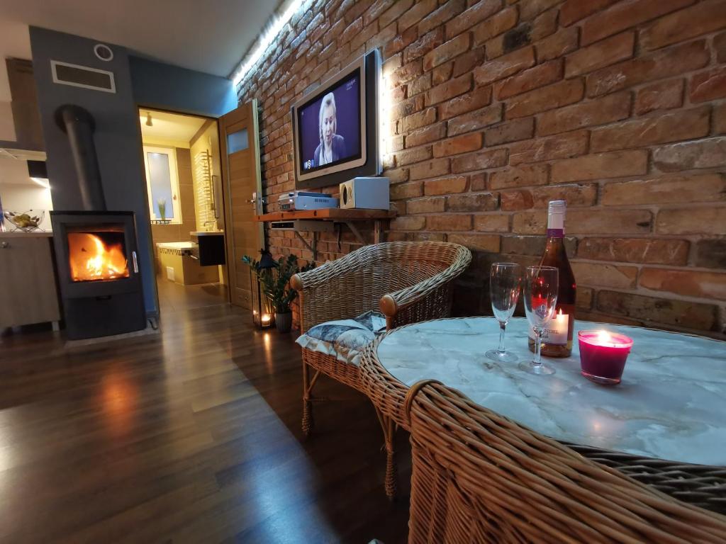 a living room with a table with wine glasses and a fireplace at DOMAGAŁA Domek z kominkiem in Łagów