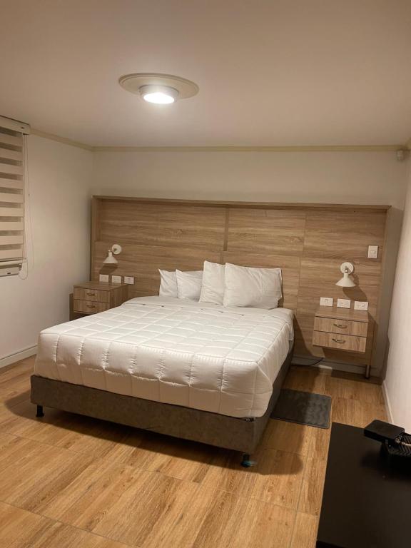 a bedroom with a large bed with a wooden headboard at Hermoso Aparta estudio amoblado en Pereira in Pereira