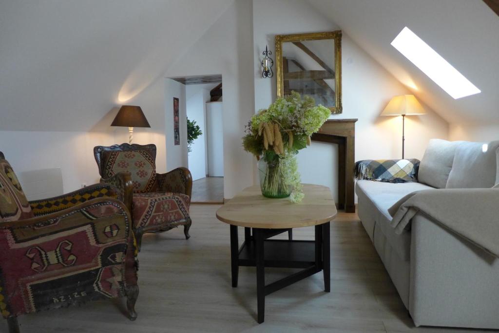 a living room with a vase of flowers on a table at Un bijou au cœur de Belleme in Bellême