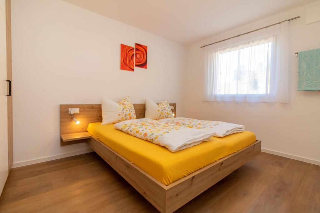 ein Schlafzimmer mit einem großen gelben Bett und einem Fenster in der Unterkunft SUNNLEITN HOF in Deutschnofen