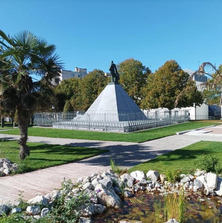 statua pośrodku parku ze stawem w obiekcie Au jardin de la Basilique w mieście Boulogne-sur-Mer