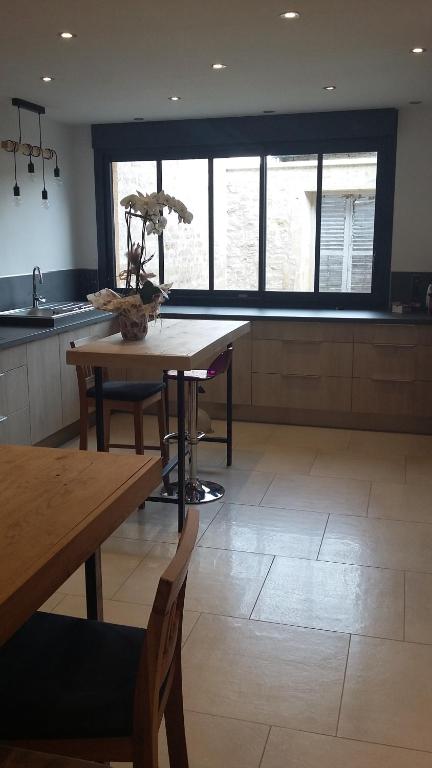 cocina con mesa, 2 sillas y ventanas en Maison moderne proche RN4, 