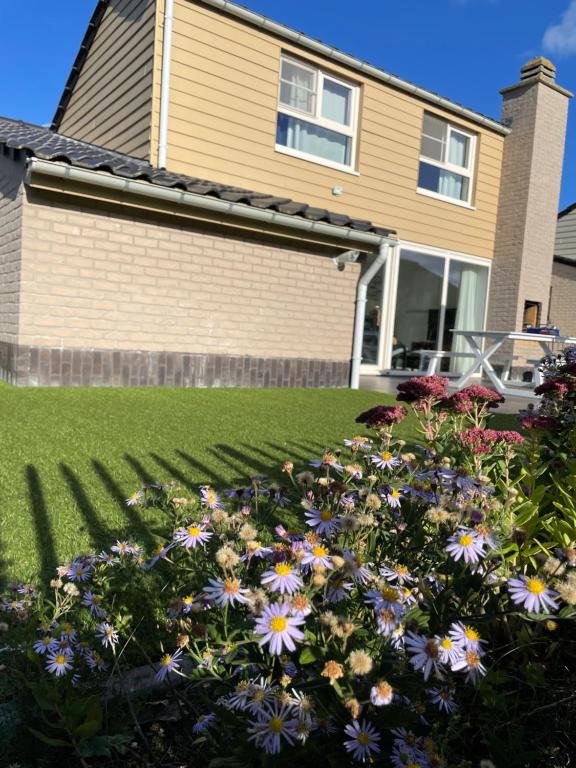 een huis met bloemen in de voortuin bij Westerhuisje in Middelkerke