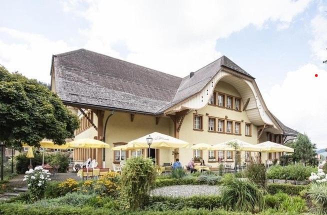 a large house with tables and umbrellas in front of it at Gasthof Kreuz Marbach in Marbach