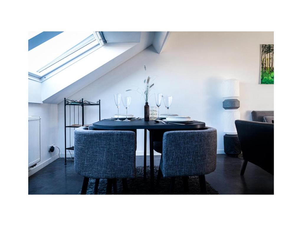 a dining room with a black table and chairs at Central Perk Apartments-Antwerp in Antwerp