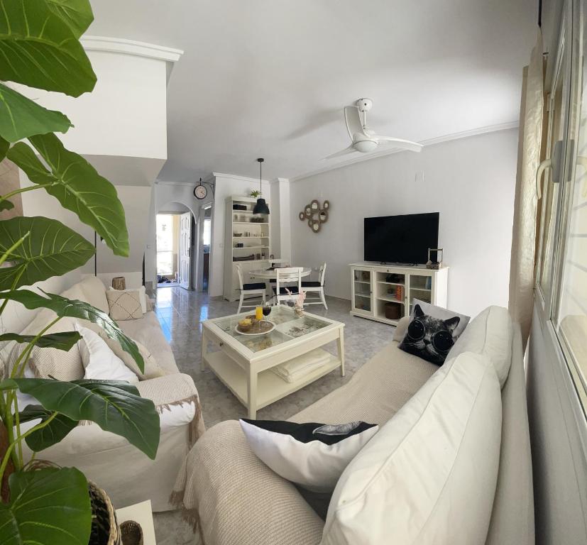sala de estar con 2 sofás blancos y TV en HOUSE CLOSE TO THE BEACH Mar Menor, en Los Narejos