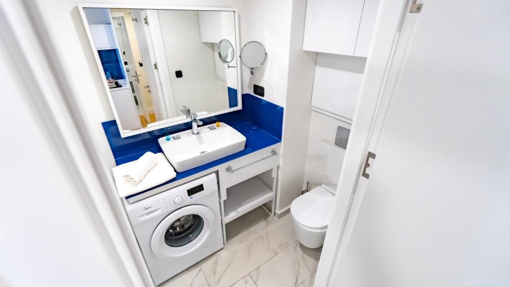 a bathroom with a sink and a washing machine at Smart Aparthotel Orbi City in Batumi