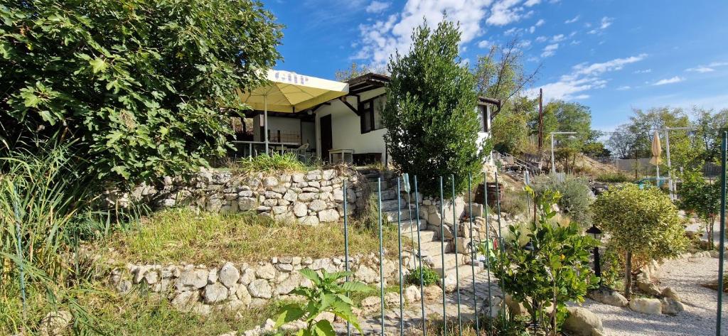 a fence in front of a house with a stone wall at Bungalow GHP-B in Varna City