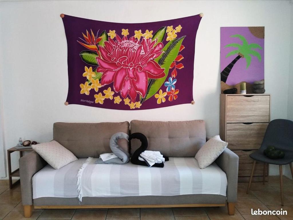 a tapestry hanging on a wall above a couch at Maison de Vacances BELIOSEA Martinique 14 Rue d'Anjou in Saint-Pierre