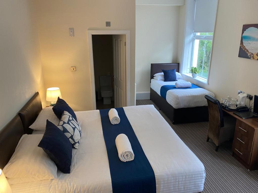 a hotel room with two beds and a desk and a desk at The New Brighton Hotel in New Brighton