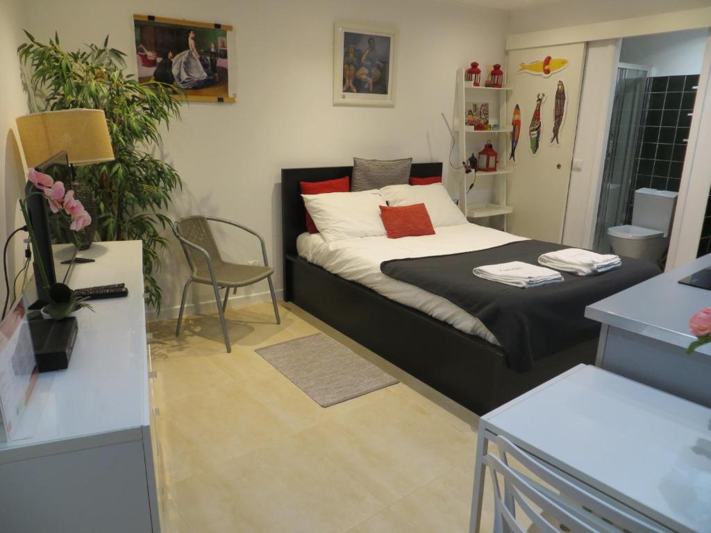 ein Schlafzimmer mit einem Bett und einem Tisch mit einer Pflanze in der Unterkunft FLH Casa Carol Mouraria in Lissabon
