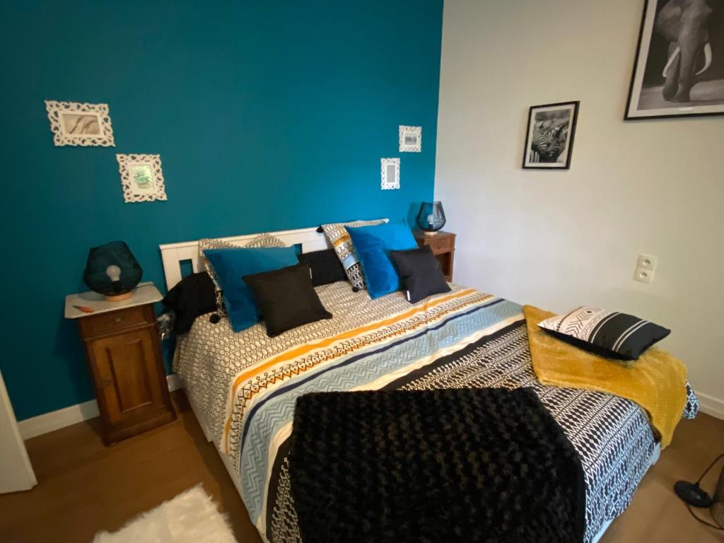 1 dormitorio con 1 cama con paredes azules en Belle Chambre Privée - Sdb - cuisine partagée - Wifi - Jardin en Wissembourg