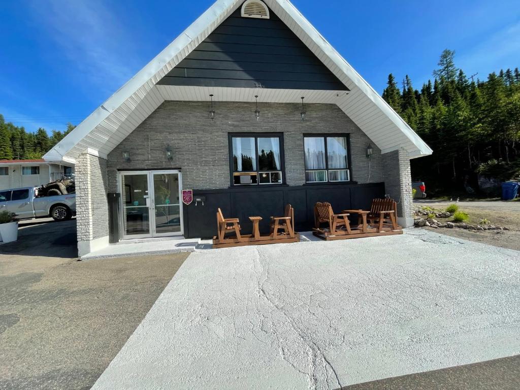 una casa con sillas y mesas en un aparcamiento en Motel du rosier, en Baie-Comeau