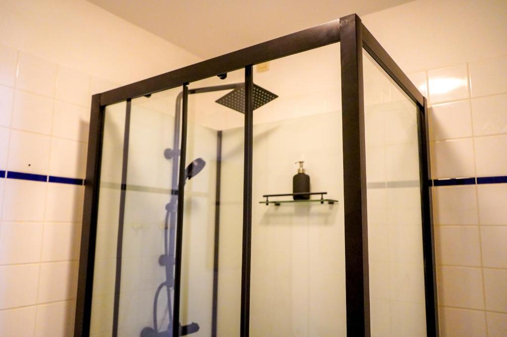 La salle de bains est pourvue d'une douche avec une porte en verre. dans l'établissement Garden Botanique, à Bruxelles