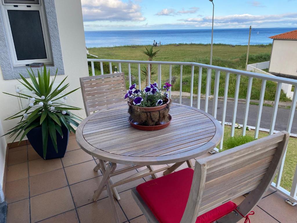 uma mesa e duas cadeiras numa varanda com o oceano em Mountain and Ocean View em Água de Alto