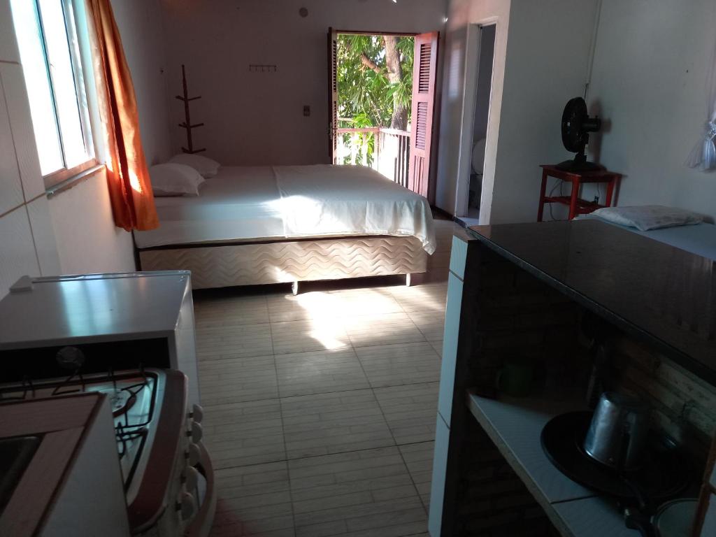 a small bedroom with a bed and a window at Paracuru Olaonda wavehostel in Paracuru