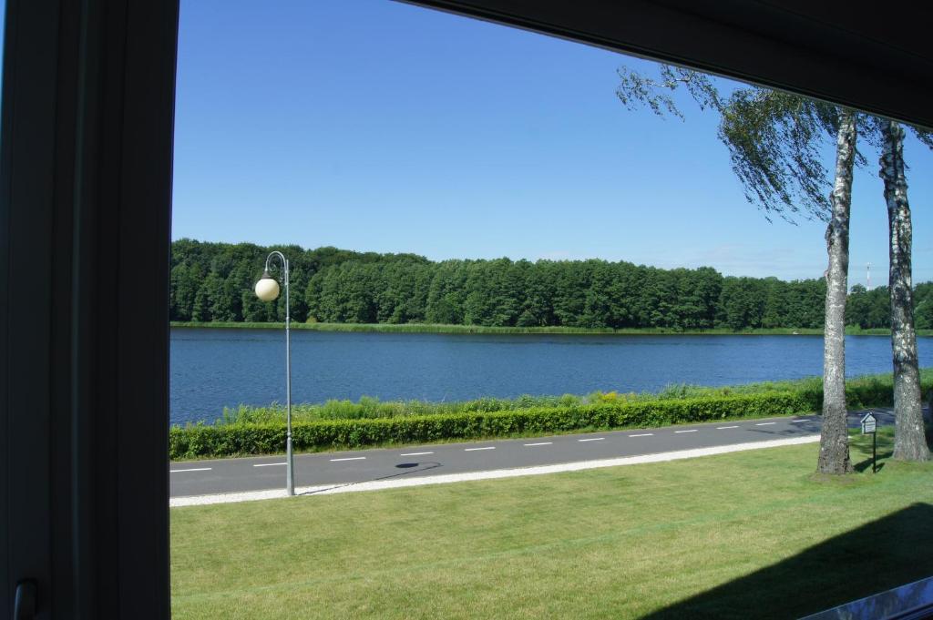 uma vista para uma estrada e um lago a partir de uma janela em Apartamenty Promenada Złotów em Złotów