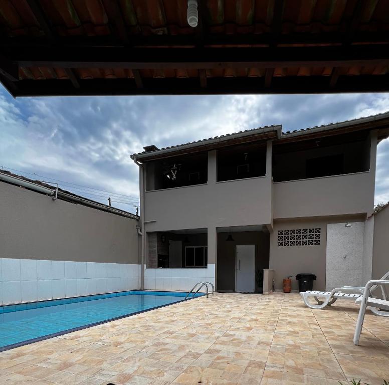 a house with a swimming pool in front of it at Casa de Praia com piscina in Boicucanga