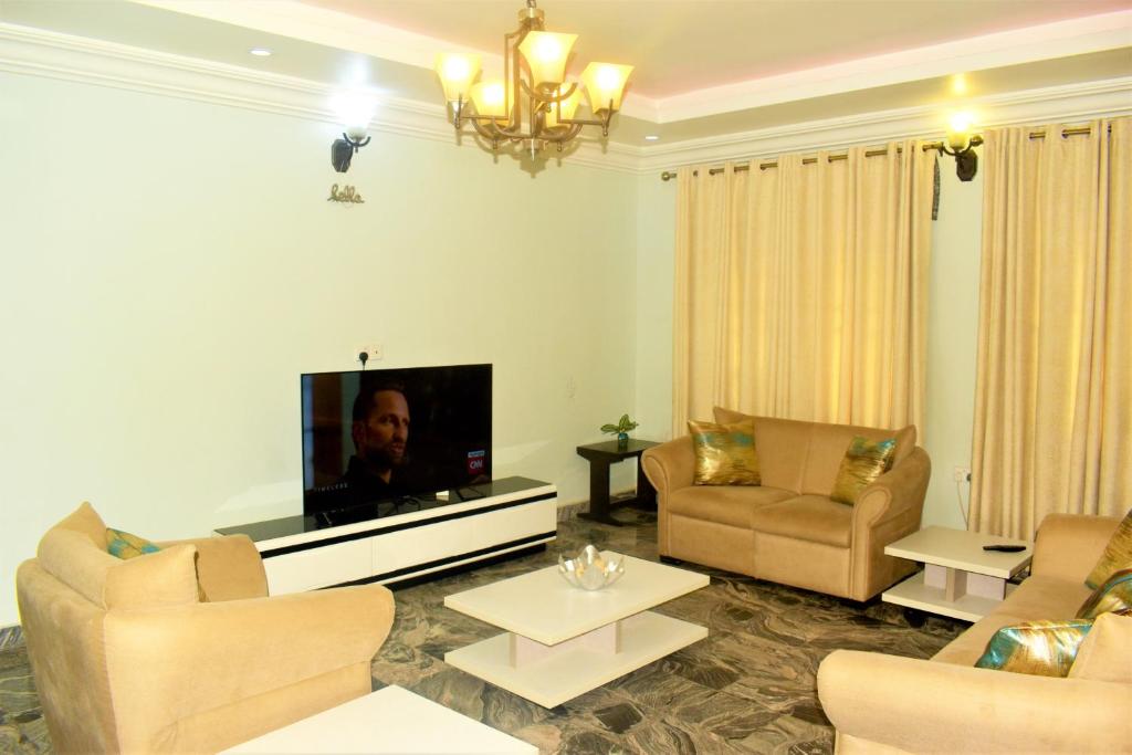  Il comprend un salon meublé doté d'une télévision à écran plat. dans l'établissement Opal Ville Bamboo Suite, 2-bedroom in a serene area, à Abuja