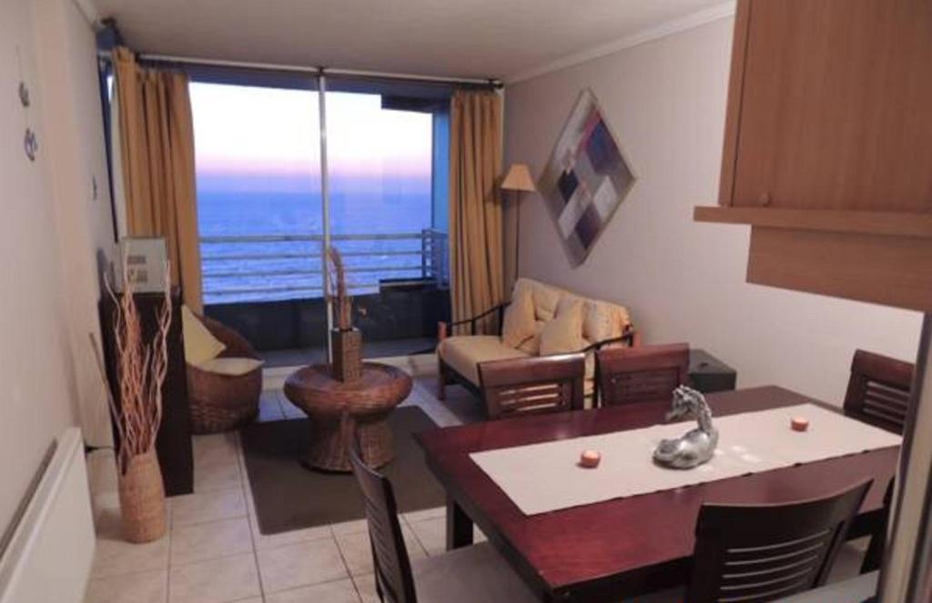 a living room with a table and a dining room at Departamento Reñaca FRENTE AL MAR in Viña del Mar