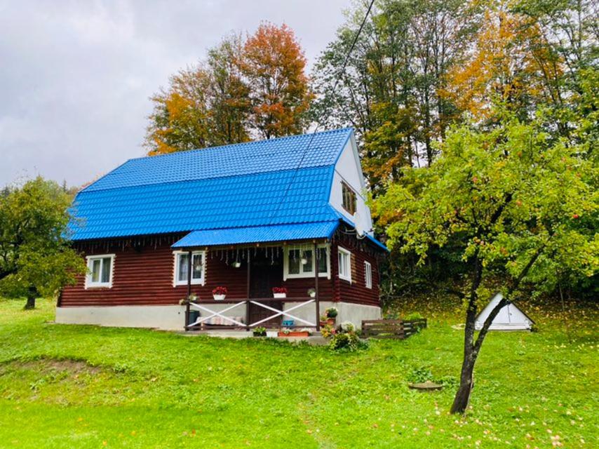 Casa roja y blanca con techo azul en Sadyba na Luzi, en Verkhne-Studënyy