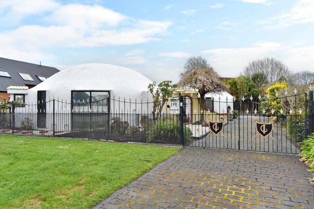 una casa blanca detrás de una valla en Koepel House - Christchurch Holiday Homes, en Christchurch