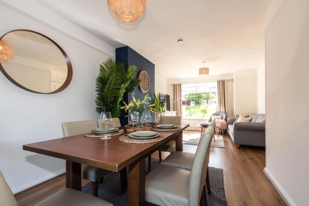 una sala da pranzo con tavolo e specchio di 3 Bedrooms house ideal for long Stays! a Southampton