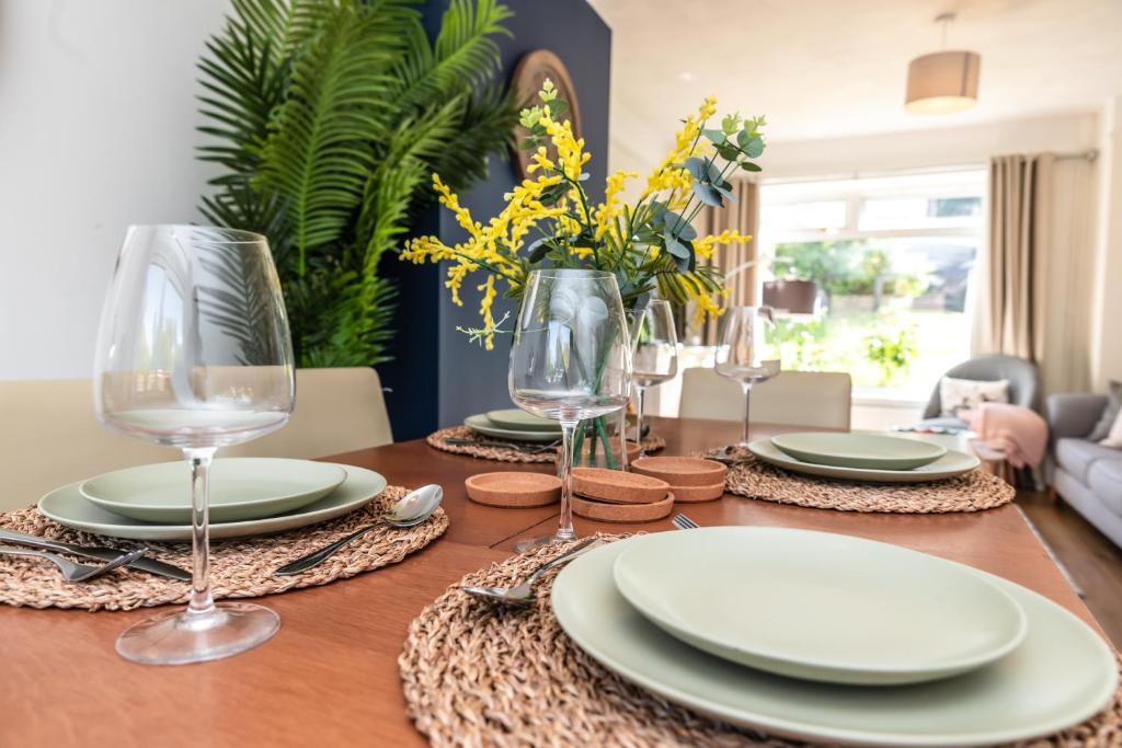 uma mesa de madeira com pratos e copos de vinho em 3 Bedrooms house ideal for long Stays! em Southampton