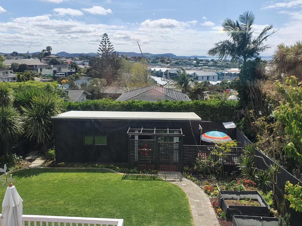 a backyard with a bird cage and a garden at Red Beach Garden Cottage in Red Beach