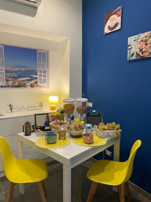 einen Tisch mit Essen drauf mit zwei gelben Stühlen in der Unterkunft Giulieda in Wonderland in Neapel