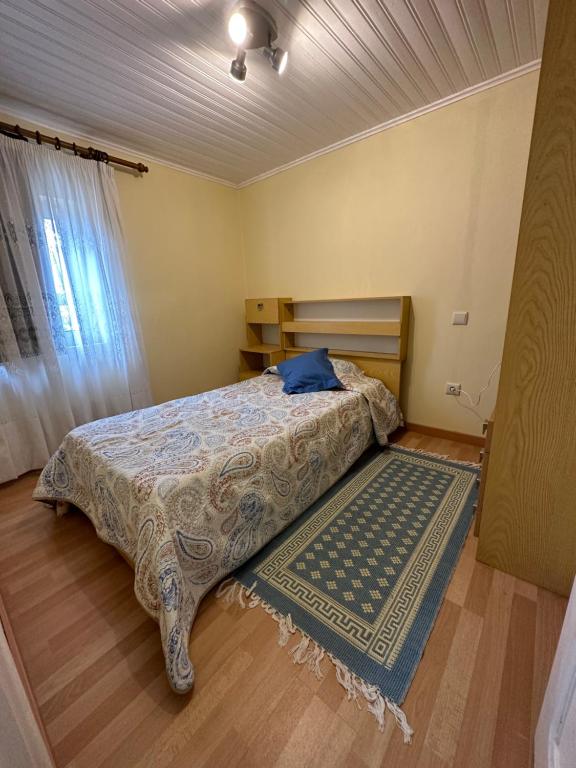 a bedroom with a bed and a rug on the floor at Casa Violeta in Águeda