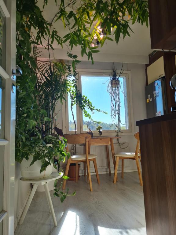 uma sala de estar com uma mesa e algumas plantas em Paradise apartment em Vantaa