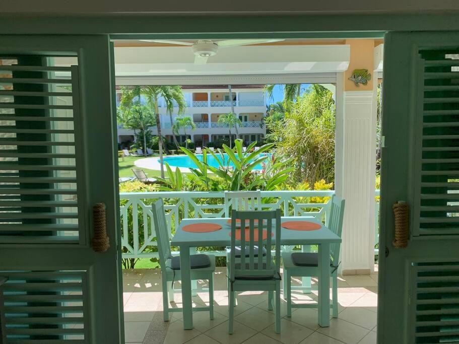 a porch with a table and chairs and a pool at Excelente apartamento en Las Terrenas, Playa Punta Popi. in Las Terrenas