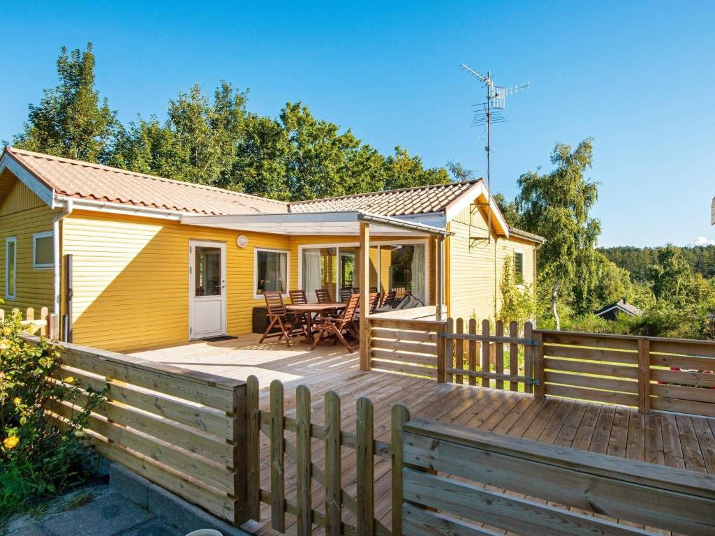 エーベルトフトにある6 person holiday home in Ebeltoftの黄色のコテージ(木製デッキ付)