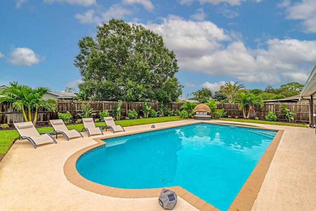 a swimming pool with lounge chairs in a yard at Private Backyard Oasis! Hot Tub & Salt Water Pool! in Sarasota