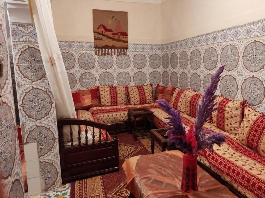 ein Wohnzimmer mit Sofas und einem Tisch im Zimmer in der Unterkunft Une maison au centre de l'ancienne Médina in Marrakesch