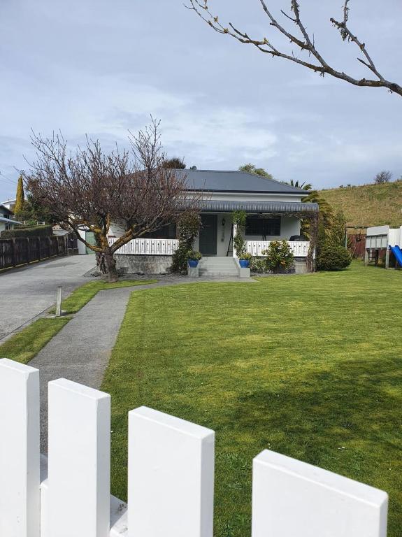 a white picket fence in front of a house at Ludstone Villa - A charming family home in Kaikoura