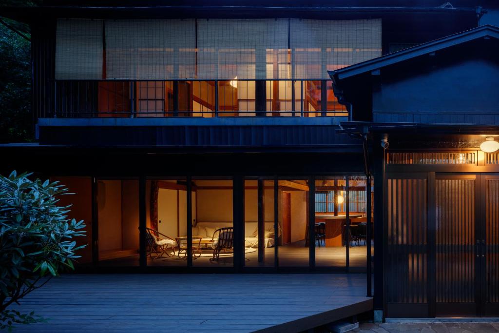 een huis met glazen deuren en 's nachts een balkon bij mysa hakone in Hakone