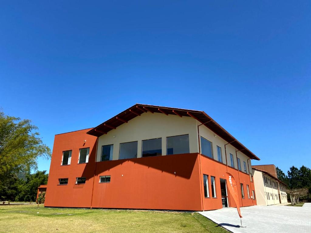 un edificio arancione con finestre sul lato di Pousada Divino Oleiro - Gov. Celso Ramos a Governador Celso Ramos
