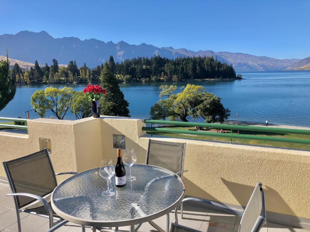 a table and chairs with a view of a lake at Lakefront Luxury Penthouse central Queenstown in Queenstown