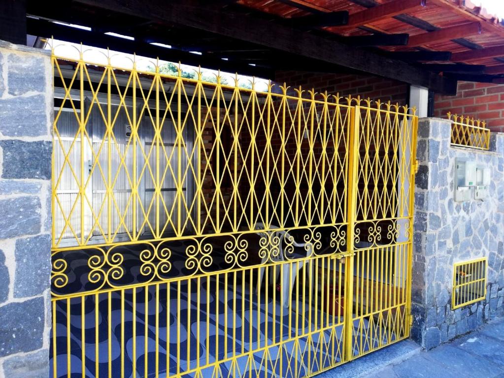 una puerta amarilla en el lateral de un edificio en Quarto Privado-Suite Aconchego-Miguel Pereira / RJ, en Miguel Pereira