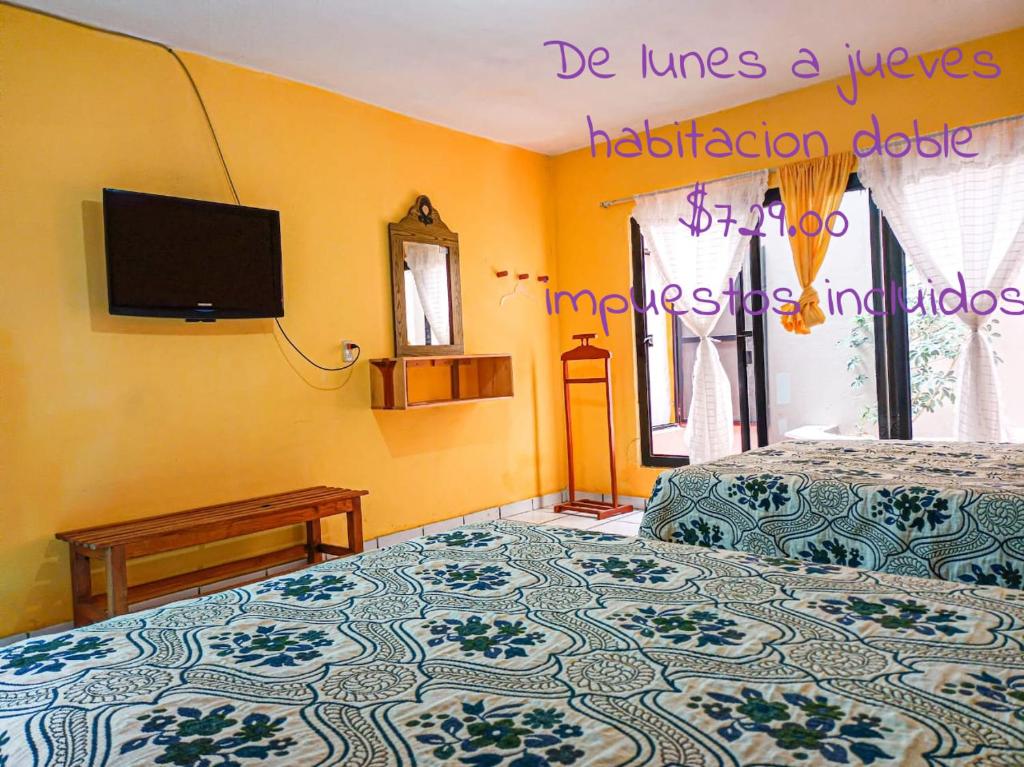 a bedroom with a bed and a tv on the wall at CASA GRANDE HERMOSA in Erongarícuaro