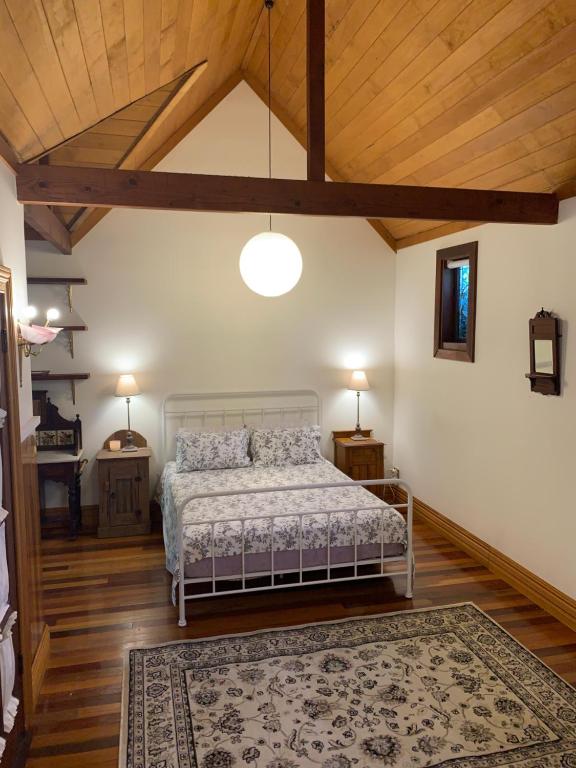 1 dormitorio con cama y techo de madera en Garden studio, en Glenbrook