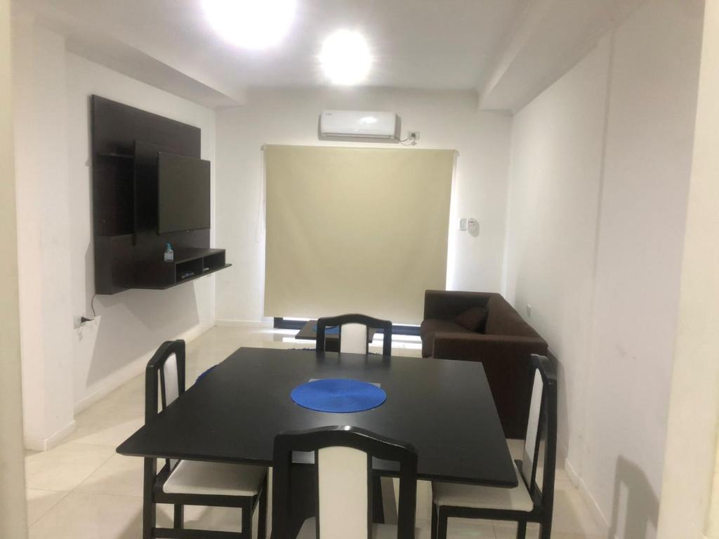 uma sala de jantar com uma mesa preta e cadeiras em punto de encuentro em Corrientes