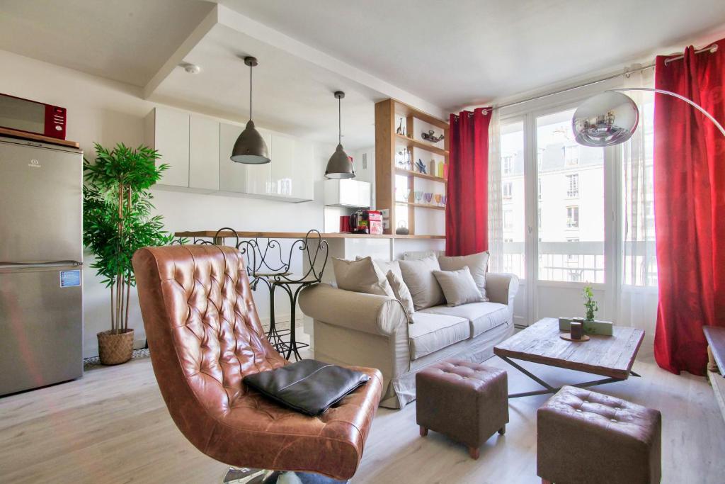 ein Wohnzimmer mit einem Sofa und einem Tisch in der Unterkunft Studio Republique Pierre Levé in Paris