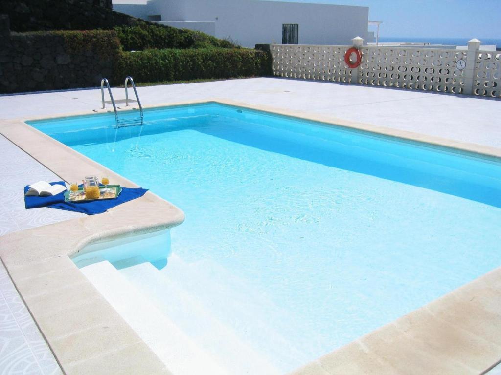 a large swimming pool with blue water in a backyard at Villas Don Rafael in Puerto del Carmen