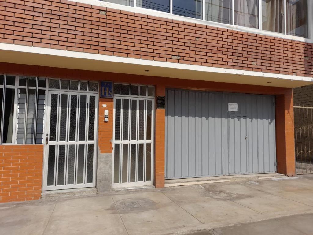 three garage doors in a brick building at Hostal San Antonio in Chimbote