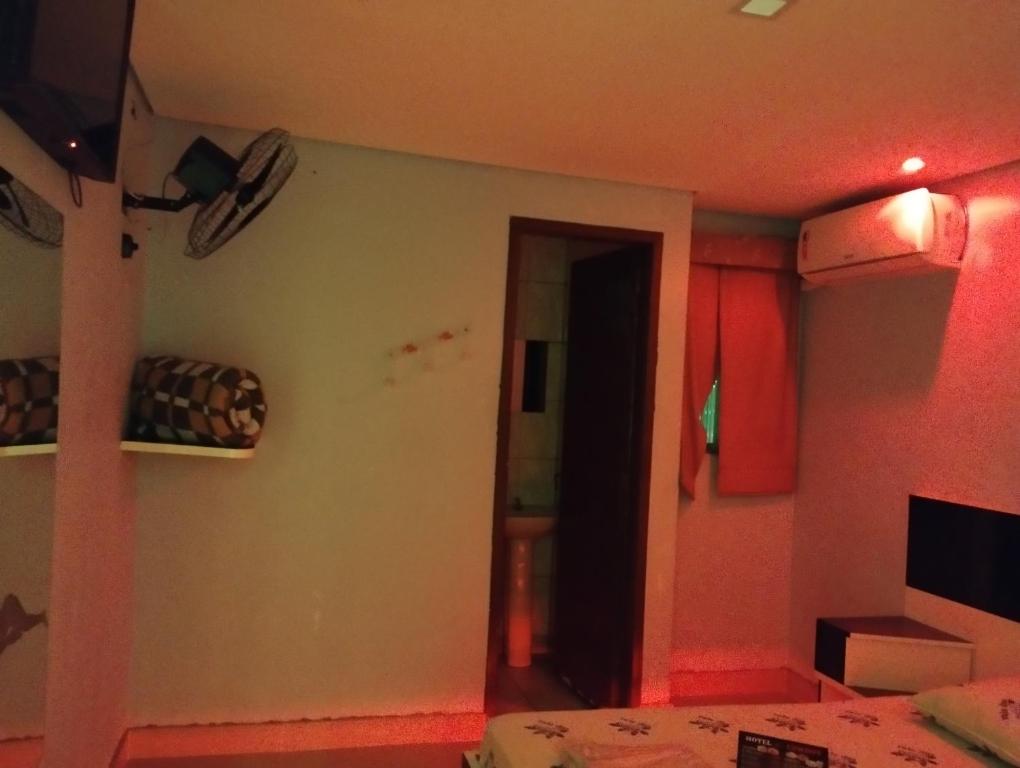 a room with a bed and a room with red lights at Hotel cowboy Cidade Dutra in Sao Paulo