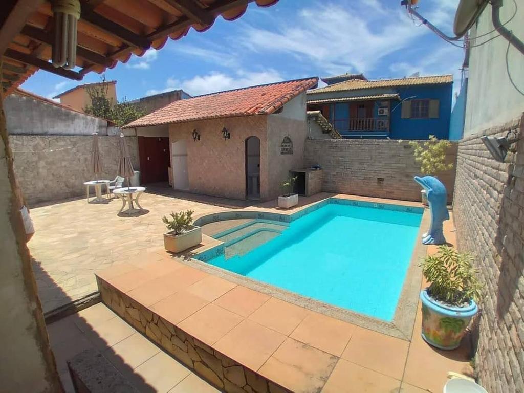 ein großer Pool in einem Hof mit einem Haus in der Unterkunft CASA MATTOS in São Pedro da Aldeia